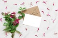 Blank white greeting card in frame made of pink honeysuckle flowers over white marble table Royalty Free Stock Photo