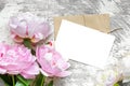 Blank white greeting card with pink peony flowers bouquet and envelope on white wooden background. flat lay. top view Royalty Free Stock Photo