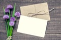 Blank white greeting card with purple wildflowers bouquet and envelope over rustic wooden background Royalty Free Stock Photo