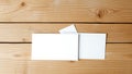 Blank white greeting cards and envelopes arranged on a distressed light brown wooden surface with visible grain and texture Royalty Free Stock Photo