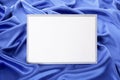 Blank white greetings card or invitation with blue satin background, copy space Royalty Free Stock Photo