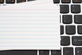 Blank white index card on a black and silver keyboard Royalty Free Stock Photo