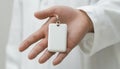 Blank White Key Tag Mockup Held In Hand On White Background, Copy Space For Your Design Or Branding Royalty Free Stock Photo