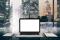 Blank white laptop screen on glassy table in modern office with Royalty Free Stock Photo