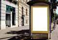 blank white lightbox ad panel along sidewalk. bus shelter advertising. blurred urban background Royalty Free Stock Photo