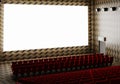 Blank white luminous cinema movie theatre screen with realistic red rows of seats and chairs with empty copy space background.