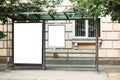 Blank white mock up of bus stop vertical billboard in front of empty street background Royalty Free Stock Photo