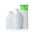 Blank white mockup dispenser and plastic bottles of cosmetic products with green lids Royalty Free Stock Photo