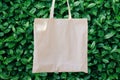 Mockup Linen Cotton Tote Bag on Green Bush Trees Foliage Background. Eco Nature Friendly. Environmental Conservation Recycling