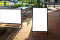 Blank white mockup template of a standing advertising sandwich board or easel panel on a pedestrian sidewalk of a street Royalty Free Stock Photo