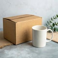 Blank white mug next to a cardboard box on a textured surface Royalty Free Stock Photo