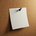 A blank white note is pinned to a textured corkboard using a black pushpin. The Royalty Free Stock Photo