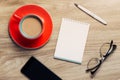 Blank white notebook open, eyeglass, pen and cup of coffee on the desk Royalty Free Stock Photo