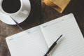 Blank white notebook and pen with cup of coffee on wooden table Royalty Free Stock Photo