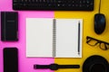 Blank white notepad with black office and personal accessories  on two tone pink and yellow background Royalty Free Stock Photo