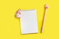 Blank white notepad on a spiral with a pink pen. Top view with copy space, flat lay on yellow background Royalty Free Stock Photo