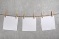 Blank white notes of paper hang with clothespins on rope. Copy space. Place for your text Royalty Free Stock Photo