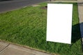 Blank white outdoor advertising stand/sandwich board mockup template. Clear street signage board placed on grass/nature stripe on Royalty Free Stock Photo