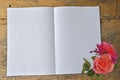 Blank white pages of book and roses on wooden floor Royalty Free Stock Photo