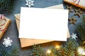 Blank white paper card with brown envelop, Christmas pine and handmade gift box on grey background Royalty Free Stock Photo