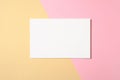 Blank white paper card on two color pastel pink and yellow background. Flat lay, top view, overhead. Creative layout, greeting Royalty Free Stock Photo