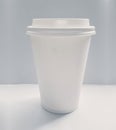 Blank white paper coffee cup isolated on a gray background. Unbranded single-use cup Royalty Free Stock Photo