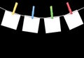 Blank white paper lists pinned with clothespins on rope isolated on black background. Blank white paper cards hanging with clothes Royalty Free Stock Photo