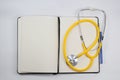 blank white paper notebook with a blue ink pen, Stethoscope, pen, and blank prescription pad. Empty medical form ready to be used. Royalty Free Stock Photo