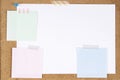 Blank white paper page and note sticks attached with adhesive tape on cork board background Royalty Free Stock Photo