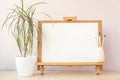 Blank white paper for painting on wooden easel on table at home studio Royalty Free Stock Photo