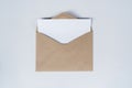 Blank white paper is placed on the open brown paper envelope. Mock-up of horizontal blank greeting card. Top view of Craft paper Royalty Free Stock Photo