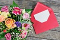 Blank white paper is placed on the open red paper envelope and flower bouquet Royalty Free Stock Photo