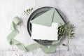 Blank white paper post card with open blue green envelope with decor on retro grey metallic tray on grunge stone background Royalty Free Stock Photo