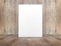 Blank white paper poster leaning at wood wall on wooden floor in Royalty Free Stock Photo