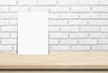 Blank white paper poster over wood table and brick wall background Royalty Free Stock Photo