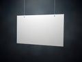 Blank white paper sign hanging on dark wall with strings Royalty Free Stock Photo