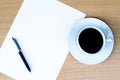 Blank white paper is on the table with ball pen and coffee aside Royalty Free Stock Photo