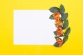 Blank white paper on a yellow background with petals and orange hibiscus flowers, greeting card mockup, design Royalty Free Stock Photo