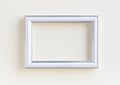 Blank white picture frame on a plain beige background.