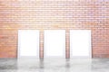 Blank white picture frames on concrete floor and red brick wall, mock up Royalty Free Stock Photo