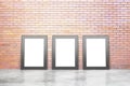 Blank white picture frames in empty loft room with concrete floor and red brick wall, mock up Royalty Free Stock Photo