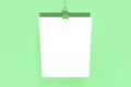 Blank white poster with binder clip mockup on green background Royalty Free Stock Photo