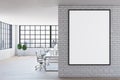 Blank white poster in black frame on light brick wall in spacious modern office with wooden floor and big window. Mock up Royalty Free Stock Photo