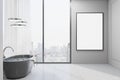 Blank white poster in black frame in stylish sunny bathroom with city view from huge window, black bath and glossy floor. 3D