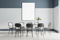 Blank white poster in black frame on the wall in modern room with big dining table with black chairs around. Mock up Royalty Free Stock Photo