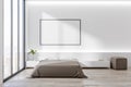 Blank white poster in black picture frame on white wall in stylish bedroom with huge window with city view, bed on wooden floor Royalty Free Stock Photo