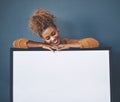 Blank white poster and copyspace of a smiling, happy and young woman holding the sign. Female looking at an empty copy Royalty Free Stock Photo