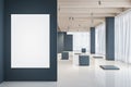 Blank white poster on grey wall in the foreground of modern and stylish empty exhibition hall with stands on marble floor and big Royalty Free Stock Photo