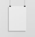 Blank white poster hanging up with clips mockup