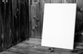 Blank white poster leaning at black and white wooden wall in plank wood room,Mock up for adding your content Royalty Free Stock Photo